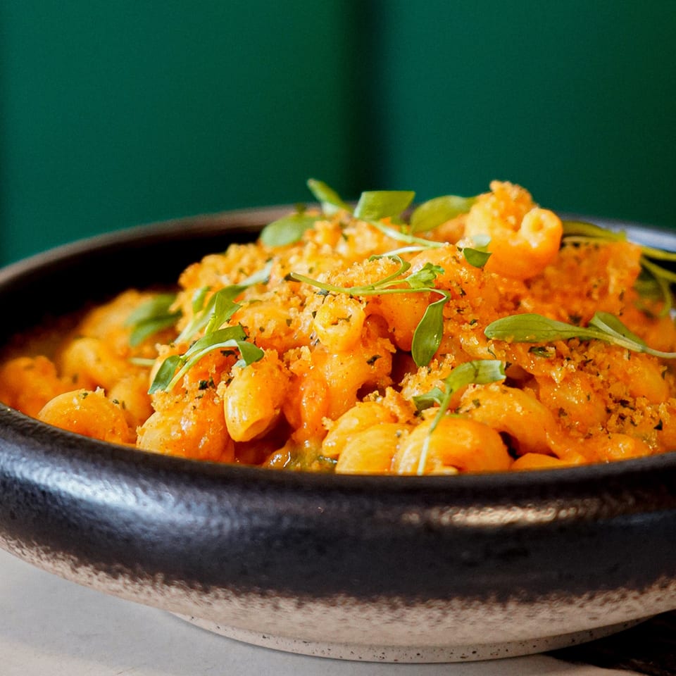 Close-up of Ladybird's vegan mac and cheese, topped with breadcrumbs and fresh herbs.